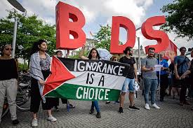 Protesters hold a Palestinian flag and the initials of the anti-Israeli BDS movement on the occasion of the visit of the Israeli prime minister in Berlin