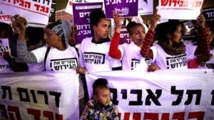 Jewish people demonstrate for equality: people of color carrying signs in Hebrew take part in a protest against the Israeli government's plan to deport African migrants, in Tel Aviv, Israel on March 24, 2018 