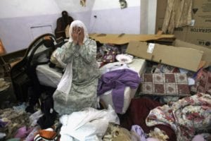 A Palestinian woman cries in her home after a raid by Israeli troops as part of Operation Brothers Keeper, Sunday, June 22,2014. 