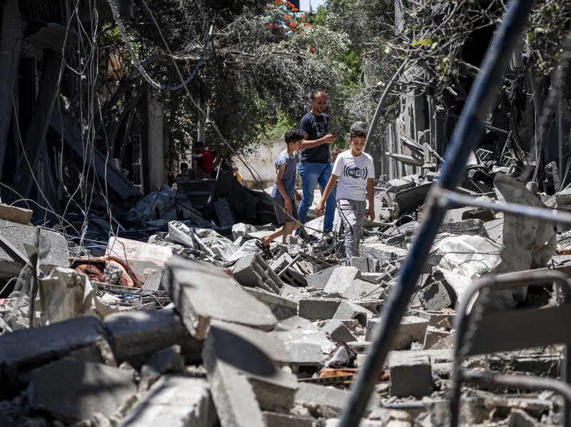 gazan children view a destroyed neighborhood