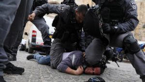 Israeli police officers detain a Palestinian protestor during scuffles outside the compound housing al Aqsa Mosque in Jerusalem's Old City March 12, 2019.