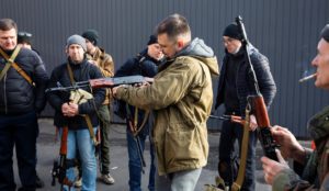 Ukrainian civilians fit their weapons to repel Russian forces in Kyiv, Ukraine on Saturday.
