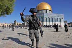 A member of the Israeli security forces attacks worshippers at the Dome of the Rock mosque during clashes at Jerusalem's al-Aqsa Mosque compound, on 15 April 2022