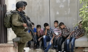 Israeli soldiers hold Palestinian children under arrest in the West Bank city of Hebron in August 2011. 