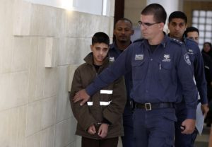 Ahmed Manasra (L), age 13, is escorted by Israeli security during a hearing at a Jerusalem court on October 30, 2015.