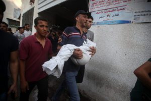 The father of Alaa Qaddoum, a five-year-old Palestinian girl, carries her body away after she was killed by an Israeli airstrike in the Shuja’iyya neighborhood of Gaza City, August 5, 2022.