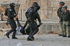 Israeli police carry an injured Palestinian demonstrator outside the Al-Aqsa Mosque complex in Jerusalem, April 22, 2022.