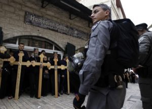 Israeli police stand in front of orthodox Christians at the Via Dolorosa near the Church of the Holy Sepulchre during Good Friday processions, April 2015.