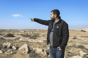 Nasser Nawajah, a community organizer and field researcher for B’Tselem, pointing to an illegal Israeli settlement in the South Hebron Hills, occupied West Bank, on Jan. 17, 2023.