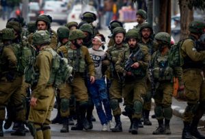 16-year-old Fawzi al-Junaidi (c) is arrested by Israeli soldiers at a protest in Hebron, December 7, 2017. 