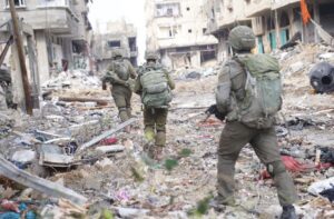 Israeli soldiers walk through a destroyed neighborhood in Gaza.