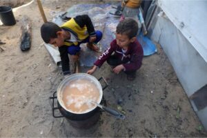 Displaced Palestinian children, who fled their house due to Israeli strikes, shelter in a tent camp in Khan Younis in the southern Gaza Strip