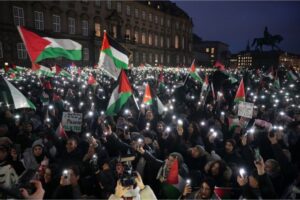People light up their phones as they participate in a pro-Palestinian rally in front of the Danish Parliament in central Copenhagen