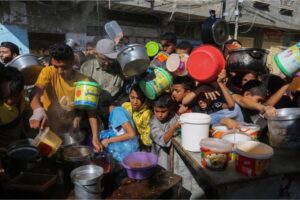 Palestinians crowd together as they wait for food distribution in Rafah in southern Gaza