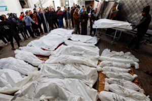 People mourn next to the bodies of Palestinians killed in Israeli strikes at Abu Yossef Al-Najar hospital, in Rafah in the southern Gaza Strip