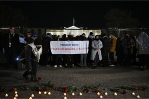 A person lays flowers during a demonstration calling for a ceasefire in Gaza in front of the White House in Washington, DC on December 13, 2023