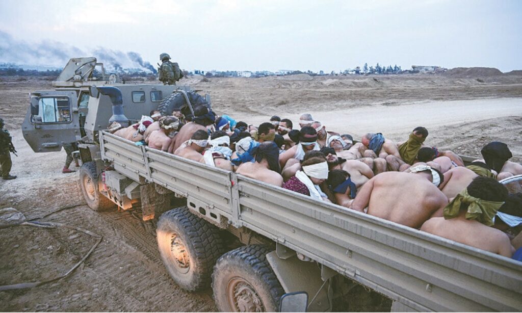 A photo, taken by a photojournalist embedded with Israeli forces during operations in Gaza, shows shirtless and blindfolded Palestinian men crammed into an Israeli military vehicle on Dec 8.