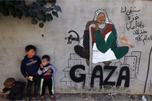 Displaced Palestinian children stand next to a mural painting by artist Amal Abo in Rafah