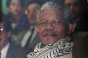 South African anti-apartheid leader and African National Congress member Nelson Mandela (C), wearing a keffiyeh, attends a meeting organised in his honour by the National Union of Algerian Youths, May 18, 1990, in Algiers