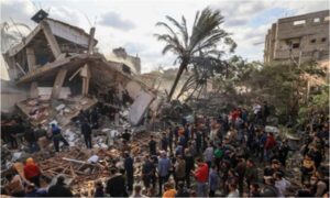 Destroyed building in Gaza surrounded by a crowd. The majority of the carbon dioxide estimated to have been produced can be attributed to Israel’s aerial bombardment and ground invasion of Gaza.