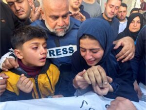 Al Jazeera journalist Wael Dahdouh comforts his daughter and son as they attend the funeral of his son, Palestinian journalist Hamza Dahdouh