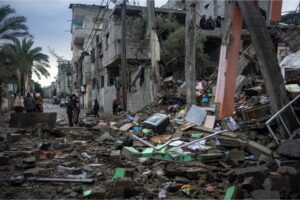 Palestinians look at the destruction after an Israeli attack in Rafah, Saturday