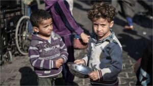 Palestinian children wait for food and humanitarian aid as Israeli airstrikes continue in Rafah, Gaza on December 19, 2023