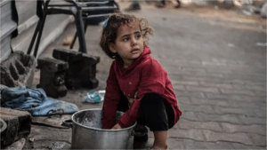 A Palestinian child displaced by Israeli attacks and forced to seek refuge in a UNRWA school, is seen struggling to survive with limited resources in Rafah, Gaza on December 31, 2023.