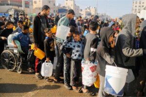 Palestinians queue as they wait to collect drinking water in Rafah