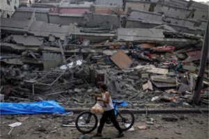 A boy walking past a destroyed building in Gaza City