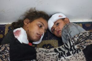 A wounded Palestinian girl comforts her brother after Israeli bombardments on Rafah on February 12, 2024