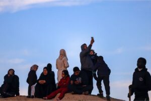 Displaced Palestinians using eSIM cards attempt to get a signal in Rafah