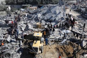 An aerial view of the civil defence teams and Palestinians conduct search and rescue operations among the rubbles of the destroyed buildings after Israeli attacks on the house belonging to the Reyyan family as Israel’s air, land and sea attacks continue on the Gaza Strip at Nuseirat refugee camp in Deir al-Balah, Gaza on February 15, 2024