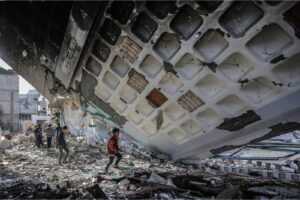 Children walk under the collapsed roof of al-Huda Mosque, destroyed in one of Israel’s airstrikes on Rafah.