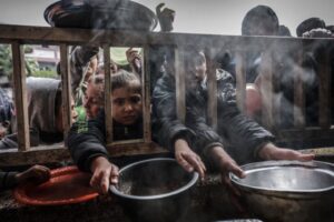 Displaced Palestinian children gather to receive food at a government school in Rafah, February 19, 2024