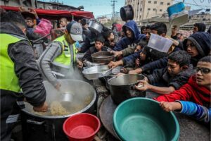 Palestinians wait for a hot meal prepared by volunteers in Rafah, southern Gaza Strip, January 26, 2024.
