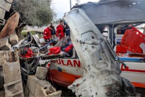 Palestinian Red Crescent personnel check a destroyed ambulance in the central Gaza Strip.