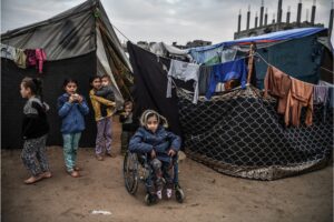 16-year-old Palestinian Nida Abid, center, who was born with a walking disability, is seen with a wheelchair amid the makeshift tents in Rafah, Gaza on February 5. Abid and her family left their homes and took refuge in Rafah