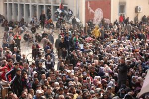 People gather in front of a UN agency for Palestinian refugees (UNRWA) building to receive flour in Jabalia on Sunday, the first convoy of aid trucks to reach northern Gaza without incident in four months.