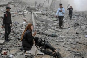 A Palestinian woman reacts as she cradles a victim after Israeli bombardment in central Gaza City on March 18, 2024