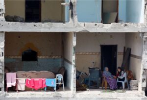 People sit at their destroyed house amid the ongoing conflict between Israel and Hamas in Rafah, in the southern Gaza Strip, March 22, 2024