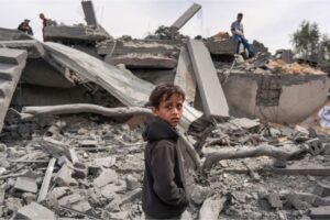 A Palestinian boy walks through the rubble of a building bombed in the Maghazi camp, central Gaza, on March 29