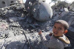 A Palestinian boy stands next to a Mosque that was destroyed by an Israeli attack in Deir el-Balah in central Gaza on Saturday
