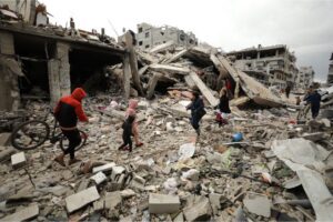 Palestinians walk on the street filled with debris of buildings destroyed due to Israeli attacks after Israeli forces withdrew from the Zeitoun neighbourhood in Gaza City following an intense ground battle with Palestinian fighters, March 7, 2024