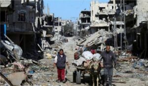 Palestinians walk amid the rubble in Khan Younis, Gaza, on Friday