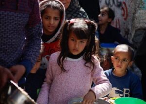 Palestinian children wait to receive food in Rafah, southern Gaza