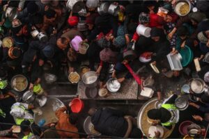 Palestinians receive food rations at a donation point at a camp for internally displaced people in Rafah