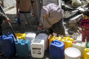 Palestinians, including children, queue with water bottles amid a clean water and food crisis as they have limited access to water due to Israeli attacks and the imposed blockade in Gaza on March 23, 2024