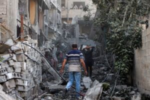 Palestinians in Gaza survey the damage following an Israeli airstrike.