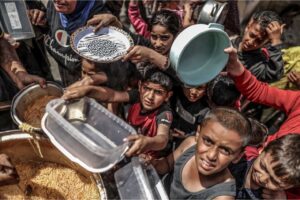 Children wait in line to receive food as Israeli attacks continue in Khan Younis